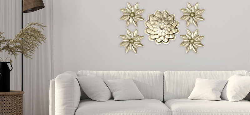  A stylish living room featuring a white sofa adorned with pillows, set against a wall of decorative golden floral wall art. 
